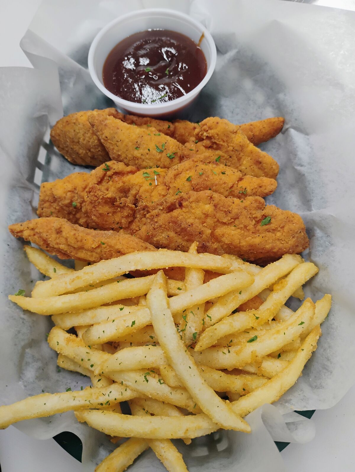 Golden crispy chicken tenders served with seasoned fries and BBQ dipping sauce