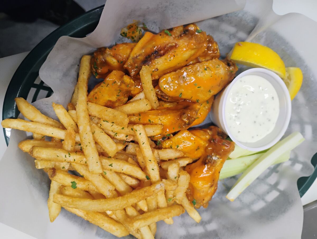 Buffalo chicken wings tossed in house sauce, served with seasoned fries, ranch dip, and celery