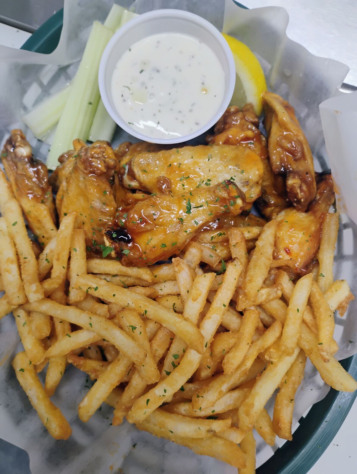 Honey-glazed chicken wings with seasoned fries, ranch dip, and celery sticks